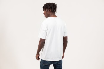 Trendy young black man in casual outfit standing in white studio