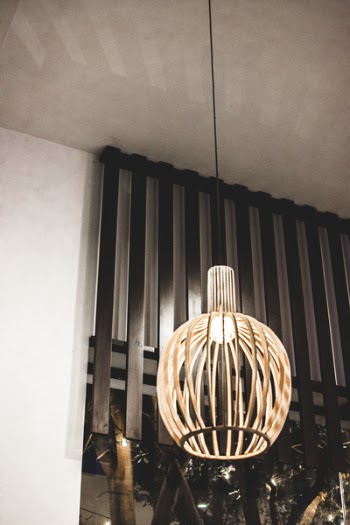 Turned-on Beige Pendant Lamp Near Window and White Walls