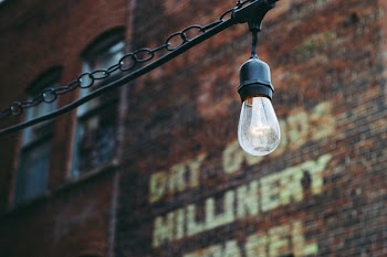 Turned on Black Lamp Near Brown Bricks Concrete Wall