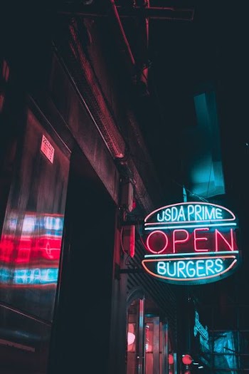 turned on blue and white Usda Prime Burgers Open neon sign