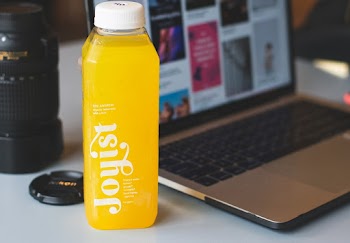 Turned On Laptop Computer Beside Plastic Bottle
