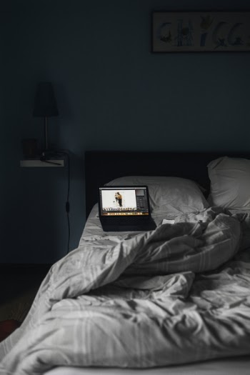 Turned-on Laptop on Bed