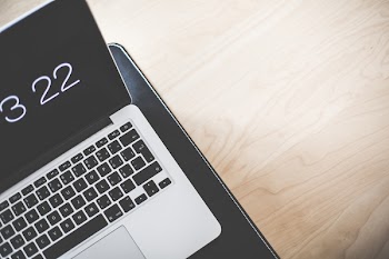 Turned on Macbook Pro on Brown Wooden Table
