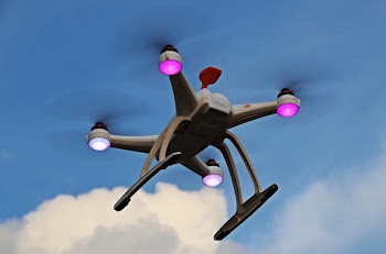 Turned-on White Quadcopter in the Sky