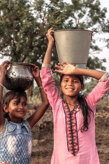 Two Asian Girls Carrying a Bucket