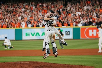 two baseball player hugging on ball park