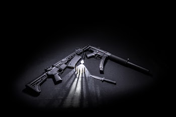 Two Black Assault Rifles Besides Tactical Knife, Bullets, and Torch.