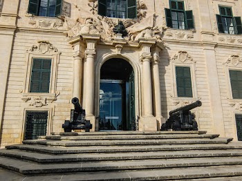 Two Black Cannons Decor in Front of White Concrete Building