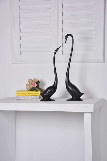 Two Black Geese Figurines on White Console Table