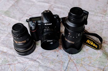 two black Nikon DSLR cmeras and lens