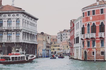 two boats on body of water between buildings