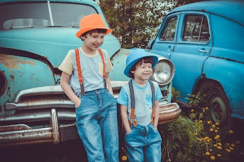 Two Boys Leaning on Classic Teal Vehicle