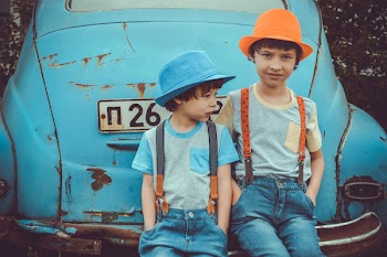 Two Boys Sitting on Blue Volkswagen Beetle Coupe's Rear Bumper