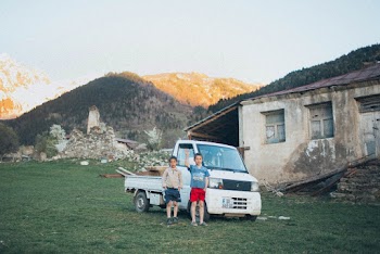 Two Boys Standing In Front Of Dropside Truck