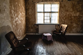 Two Brown Armchairs Beside Wall