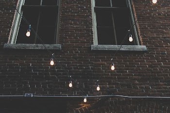 two brown windows near black string lights