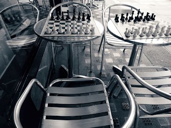 Two Chess Board and Pieces on Round Tables Beside Window