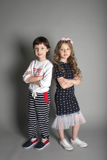 Two Children Standing While Crossing Their Arms