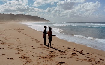 Two Children Stands on Shore Near Ocean at Daytime
