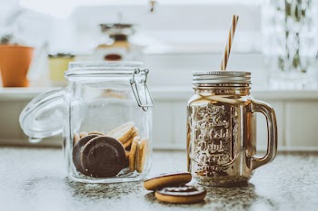 Two Clear Glass Mason Jars on Black Surface