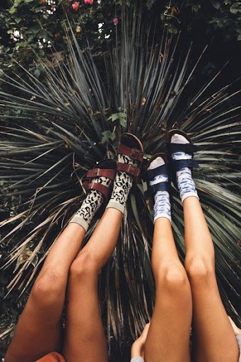 two female wearing red and blue Birkenstock sandals