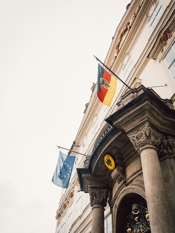 Two Flags Hanging On A Building