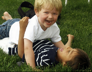 Two four year old boys engaged in rough and tumble play. The boys ...