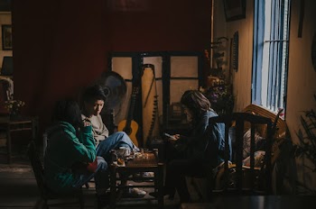 Two Girls and One Boy Sitting at Living Room