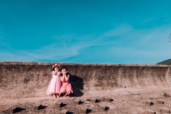Two Girls Standing Near Grey Concrete Wall