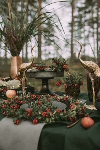 two gold swan figurines surrounded with mistletoes