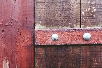 Two Gray Nails on Brown Wooden Fence