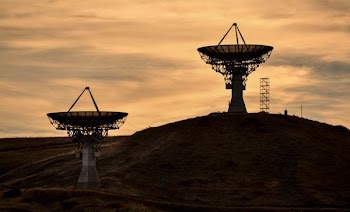 two gray satellites at sunset