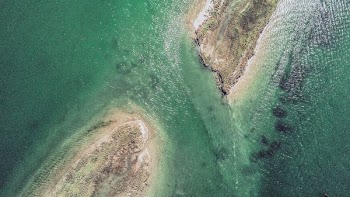 two islands surround by green body of water