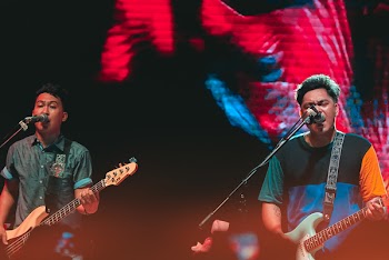 Two Male Band Members Singing on Microphones