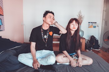 Two Man and Woman Sitting on Bed