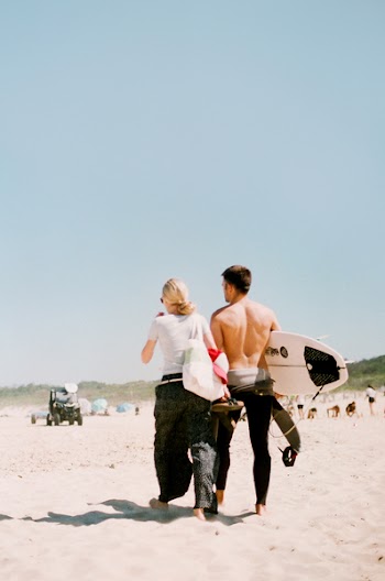 Two Man and Woman Walking on Sand