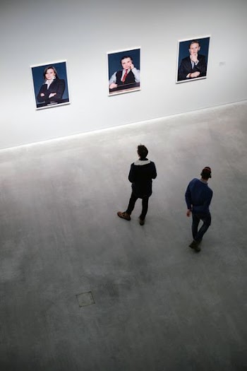 two man looking at three photos