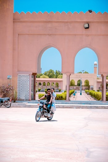 Two Man Riding Motorcycle Near Concrete Building