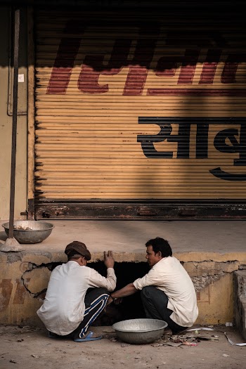 Two Man Sitting Near A Hole