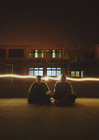 Two Man Sitting on Field