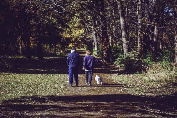 Two Man Walking on Road Near Trees
