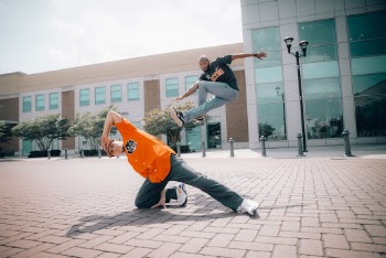 Two Men Dancing on Concrete Pavement