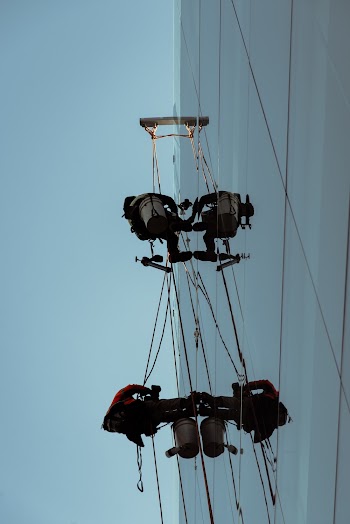 Two Men Hanging on the High-rise Building Wall