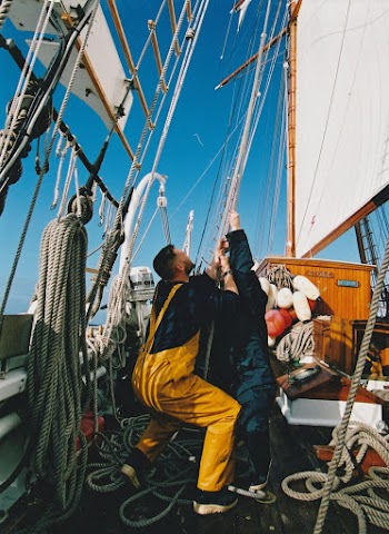 Two Men Holding Ropes of a Sailboat