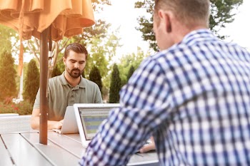 Two Men on Table Using Laptops
