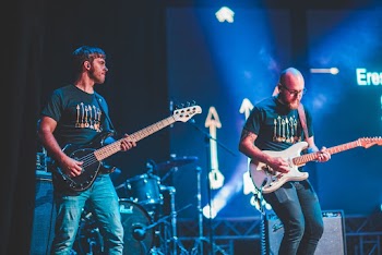 Two Men Playing Electric Guitars on Stage