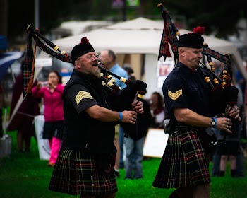 Two Men Playing Wind Instruments on Ground