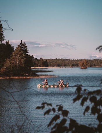 two men rowing boats in lake
