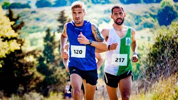 Two Men Running on Grass Field