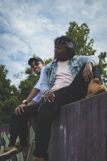 Two Men Sitting on Concrete Pavement